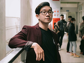 junger asiatischer Pfleger mit Brille lehnt sich an das Geländer